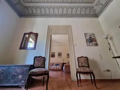 a living room with two chairs and a mirror at Piazza Politeama in Palermo