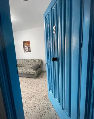 a blue door in a room with a couch at Appartamento Ponente in Balestrate