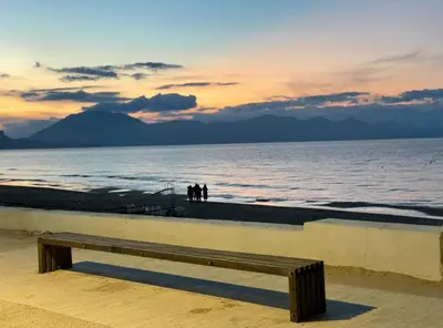 a bench sitting on the beach at sunset at Appartamento Ponente in Balestrate