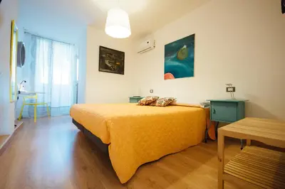 a bedroom with a bed with a yellow blanket on it at Bed à Cala in Palermo