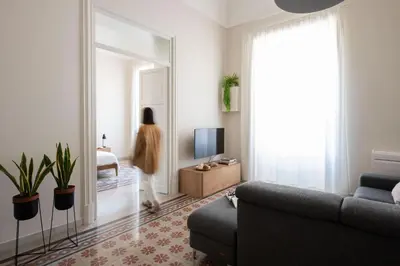 a woman standing in a living room with a mirror at Crispi Apartments in Palermo