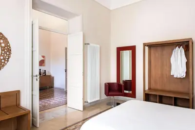 a bedroom with a bed and a red chair at Crispi Apartments in Palermo