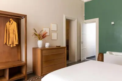 a bedroom with a bed and a dresser and a bathroom at Crispi Apartments in Palermo