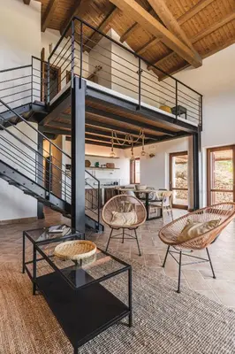 a living room with a spiral staircase and chairs at Alla Riserva - Villa Riserva dello Zingaro - Scopello in Scopello