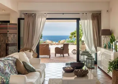 a living room with a couch and a view of the ocean at Cala Bianca (The One&Only) in Castellammare del Golfo