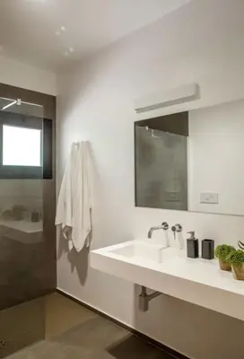 a white bathroom with a sink and a shower at Cala Bianca (The One&Only) in Castellammare del Golfo