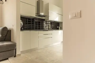 a kitchen with white cabinets and a couch in a room at Villa Balata mare e relax in Balata di Baida