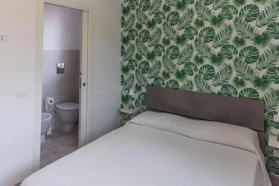 a bedroom with a bed with a green and white wallpaper at Villa Balata mare e relax in Balata di Baida