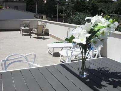 a vase of flowers sitting on a table on a patio at La Casa sul Mare in Balestrate