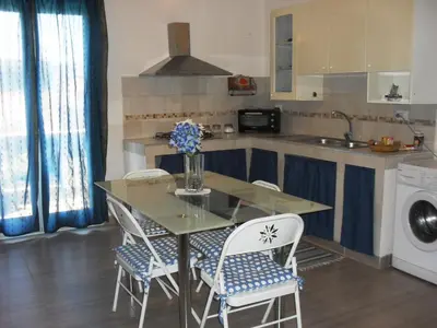 a kitchen with a table and chairs and a sink at La Casa sul Mare in Balestrate