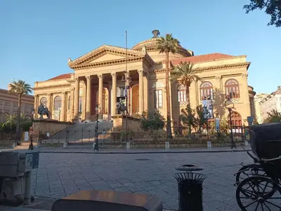 a large building with palm trees in front of it at Casa TerraMare in Palermo