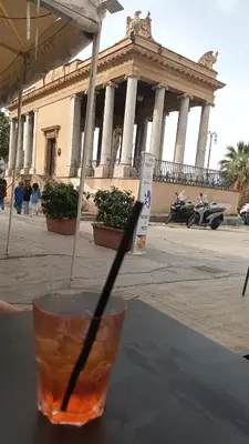 a drink sitting on a table in front of a building at Casa TerraMare in Palermo