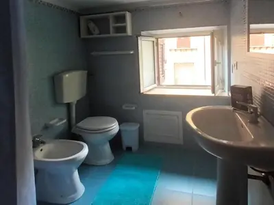 a bathroom with a toilet and a sink and a window at Casa TerraMare in Palermo