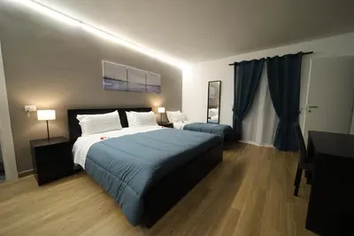 a hotel room with two beds and a desk and a bed sidx sidx sidx sidx at Boscò Suites in Carini
