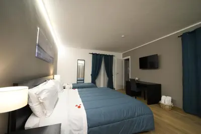 a bedroom with a bed and a desk with a computer at Boscò Suites in Carini