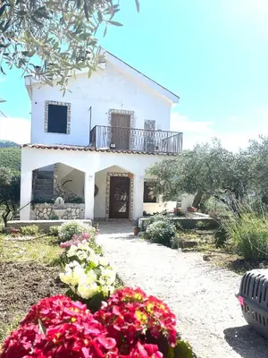 a white house with flowers in front of it at Villetta con Oliveto CFG in Prizzi