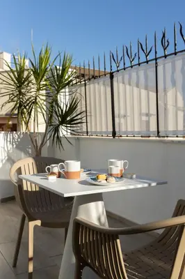 a table with a plate of food on a balcony at Peonia Boutique Apartments in Palermo