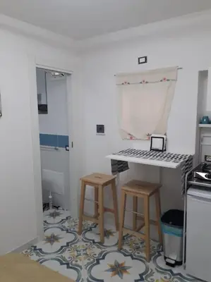 a kitchen with a table and two stools at Oneto Apartment in Palermo