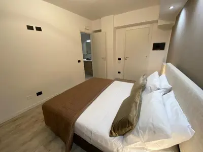 a bedroom with a bed with white sheets and pillows at Hotel Plaza Ungheria in Palermo