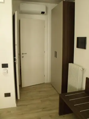 an empty room with a white door and a wooden floor at Hotel Plaza Ungheria in Palermo