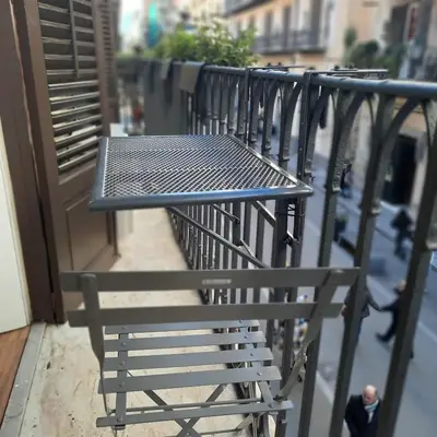 a black table and chair on a balcony at Quattrocantiapartments in Palermo