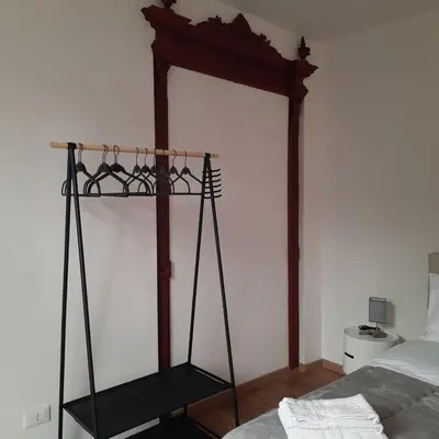 a black stand in a bedroom next to a bed at Quattrocantiapartments in Palermo