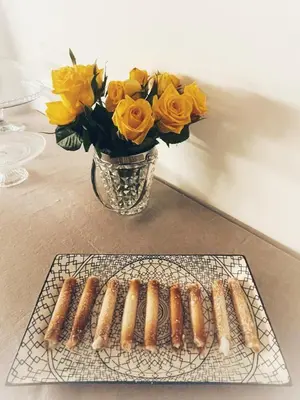 a plate of hot dogs on a rack next to a vase of flowers at Nostrale bnb in Palermo