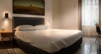 a bedroom with a large bed with white sheets and pillows at Nostrale bnb in Palermo