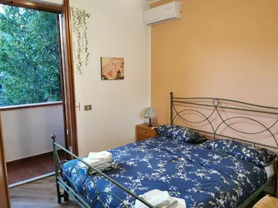 a bedroom with a bed and a large window at Villa Iris - Mondello in Palermo