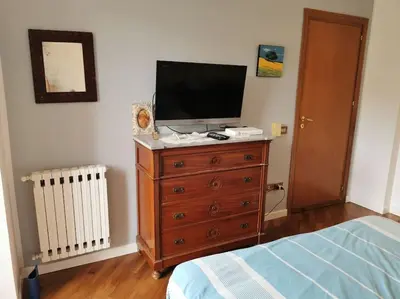 a bedroom with a television on top of a dresser at Villa Iris - Mondello in Palermo