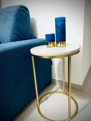 a side table with two candles on it next to a blue couch at Chalaroste home in Terrasini