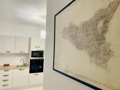 a large painting of a map on a wall in a kitchen at Chalaroste home in Terrasini