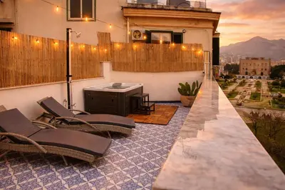 a balcony with a table and chairs on a building at Zisa Top Romantic Terrace & Private outdoor Jacuzzi in Palermo