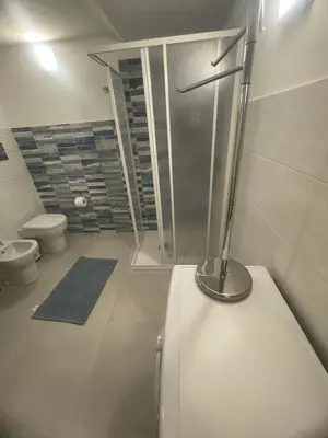a bathroom with a refrigerator and a toilet in it at appartamento francy solare in Castellammare del Golfo