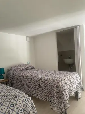 a hotel room with two beds and a mirror at appartamento francy solare in Castellammare del Golfo