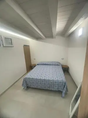 a bedroom with a bed in a white room at appartamento francy solare in Castellammare del Golfo