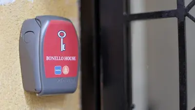 a red padlock on a wall next to a door at Bonello House Cattedrale in Palermo