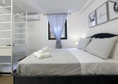 a bedroom with a white bed and a window at Bonello House Cattedrale in Palermo