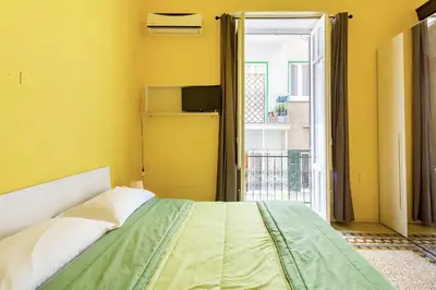 a bedroom with a bed with a yellow wall at Bohème B&B in Palermo
