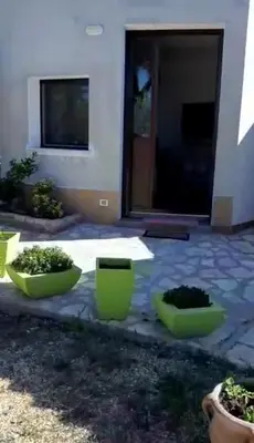 a patio with two green containers in front of a house at Camera Tina in Castellammare del Golfo