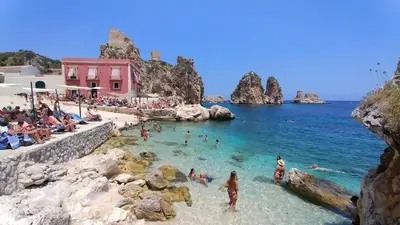 a group of people in the water at a beach at Camera Tina in Castellammare del Golfo
