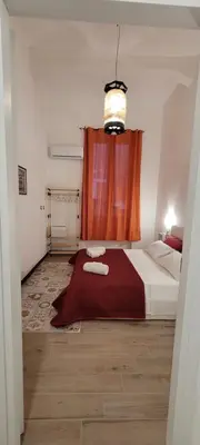 a bedroom with a bed with a red curtain at HouseStation Suite in Palermo