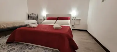a bedroom with a bed with red sheets and two towels at HouseStation Suite in Palermo