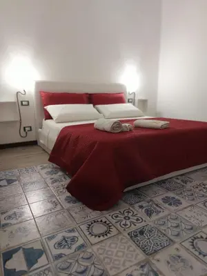 a bedroom with a bed with a red blanket and a floor at HouseStation Suite in Palermo