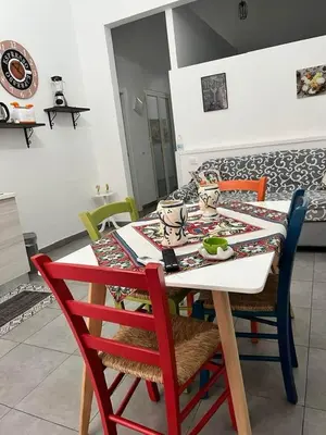 a dining room table with chairs and a table with at La Casa di Bella in Palermo