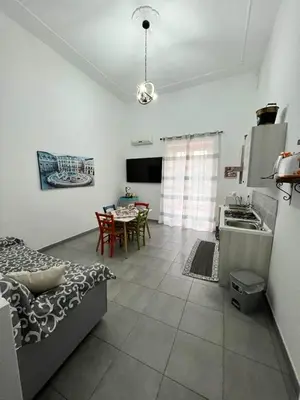 a kitchen and living room with a table and a couch at La Casa di Bella in Palermo
