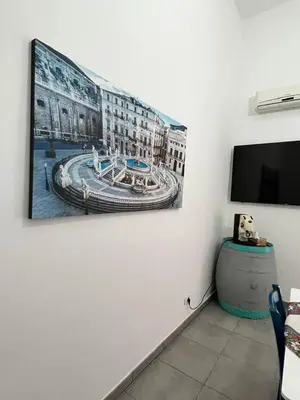 a painting on a wall in a room with a tv at La Casa di Bella in Palermo