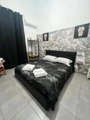 a bedroom with a black bed with towels on it at La Casa di Bella in Palermo
