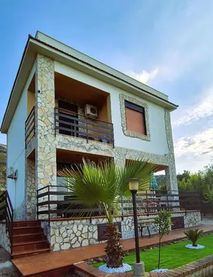 a house with a balcony with a dog on it at Villa San Lorenzo Sicily in Altavilla Milicia