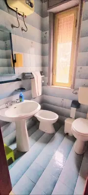 a blue and white bathroom with a sink and a toilet at Villa San Lorenzo Sicily in Altavilla Milicia